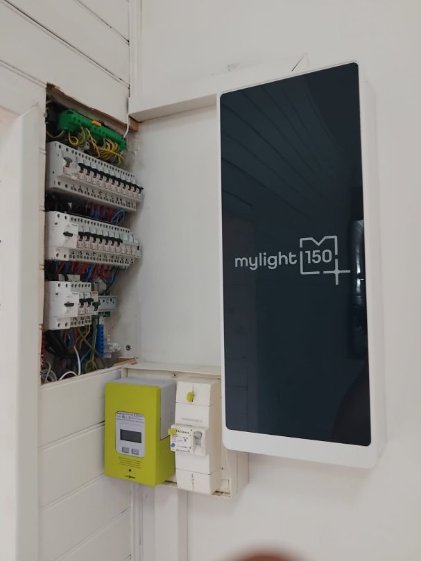 MYLIGHT sur un mur à côté d'un panneau électrique et un compteur. Écran noir monté sur un mur à côté d'un panneau électrique et un compteur.